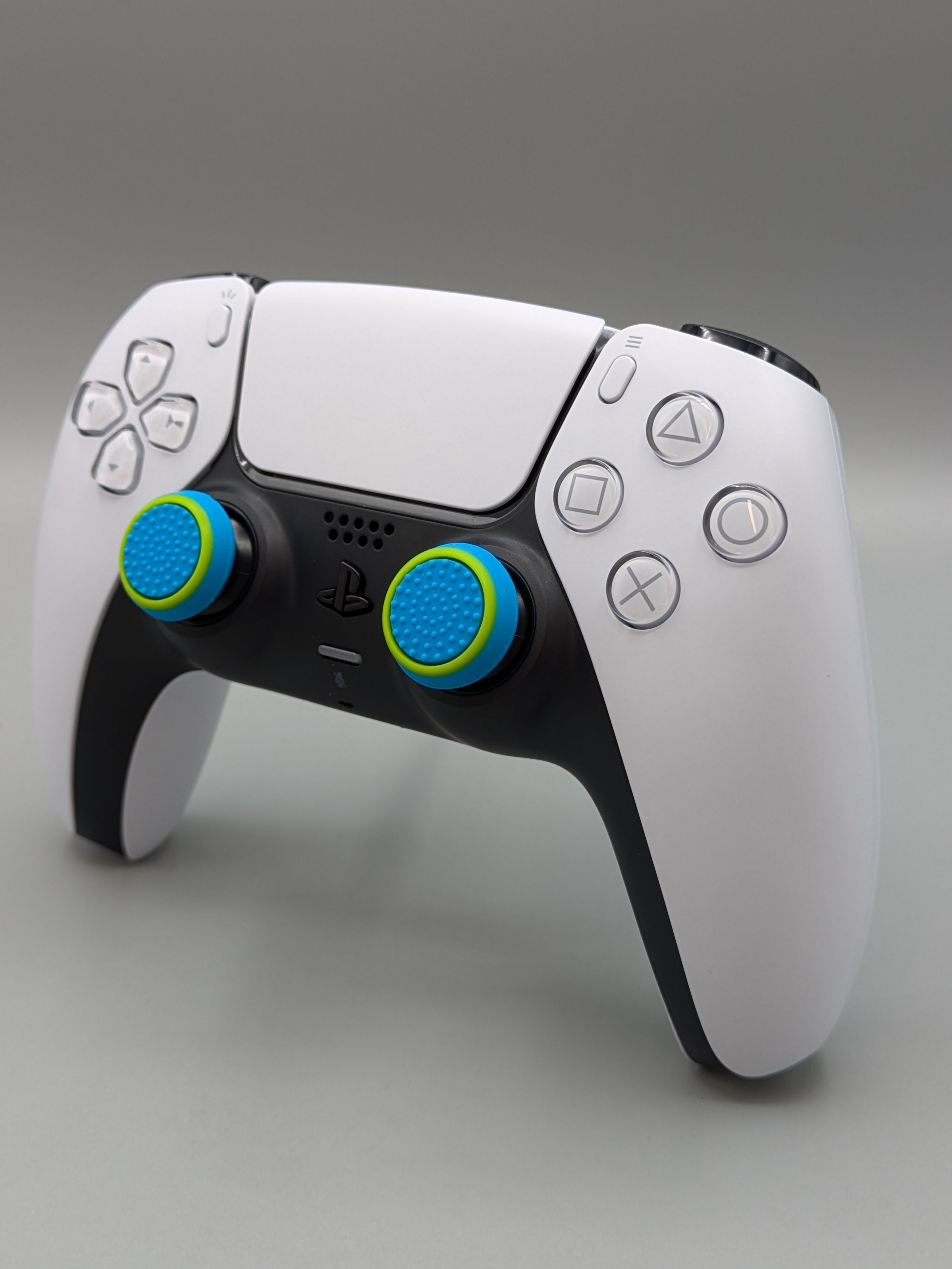 Custom PS5 controller showcasing the GOAT thumbstick toppers in blue and yellow - side view